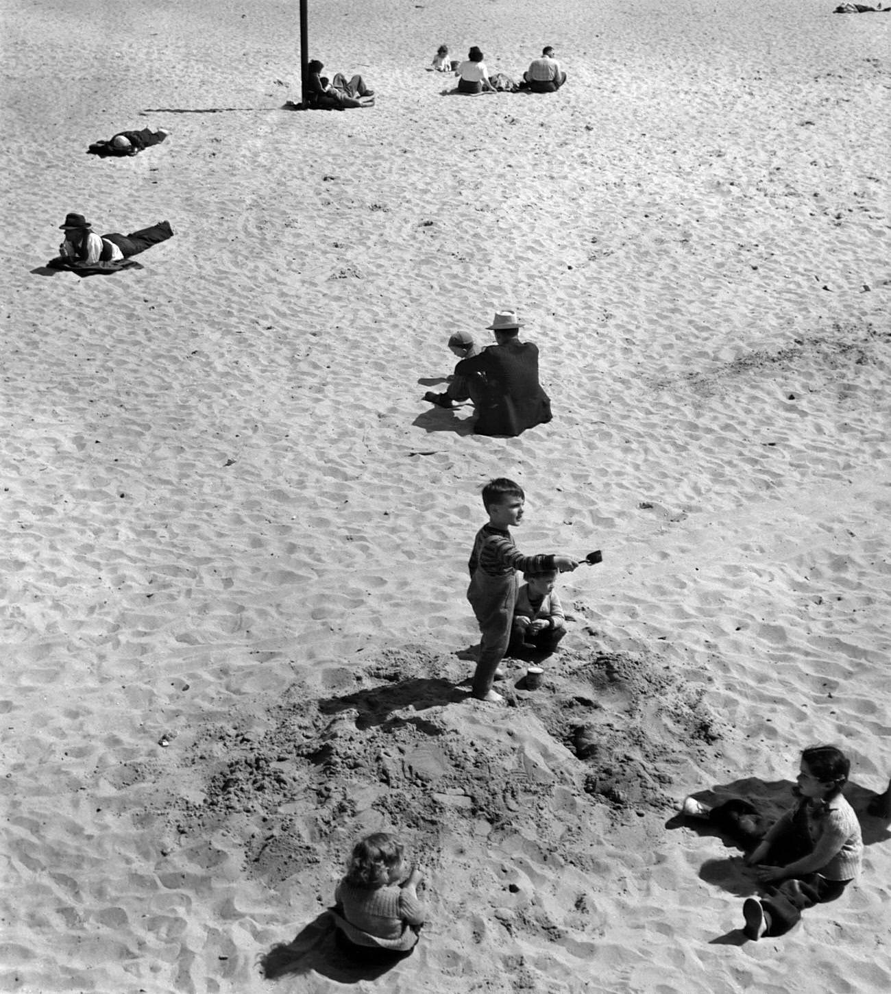 People Sitting On Coney Island Sand, 1947