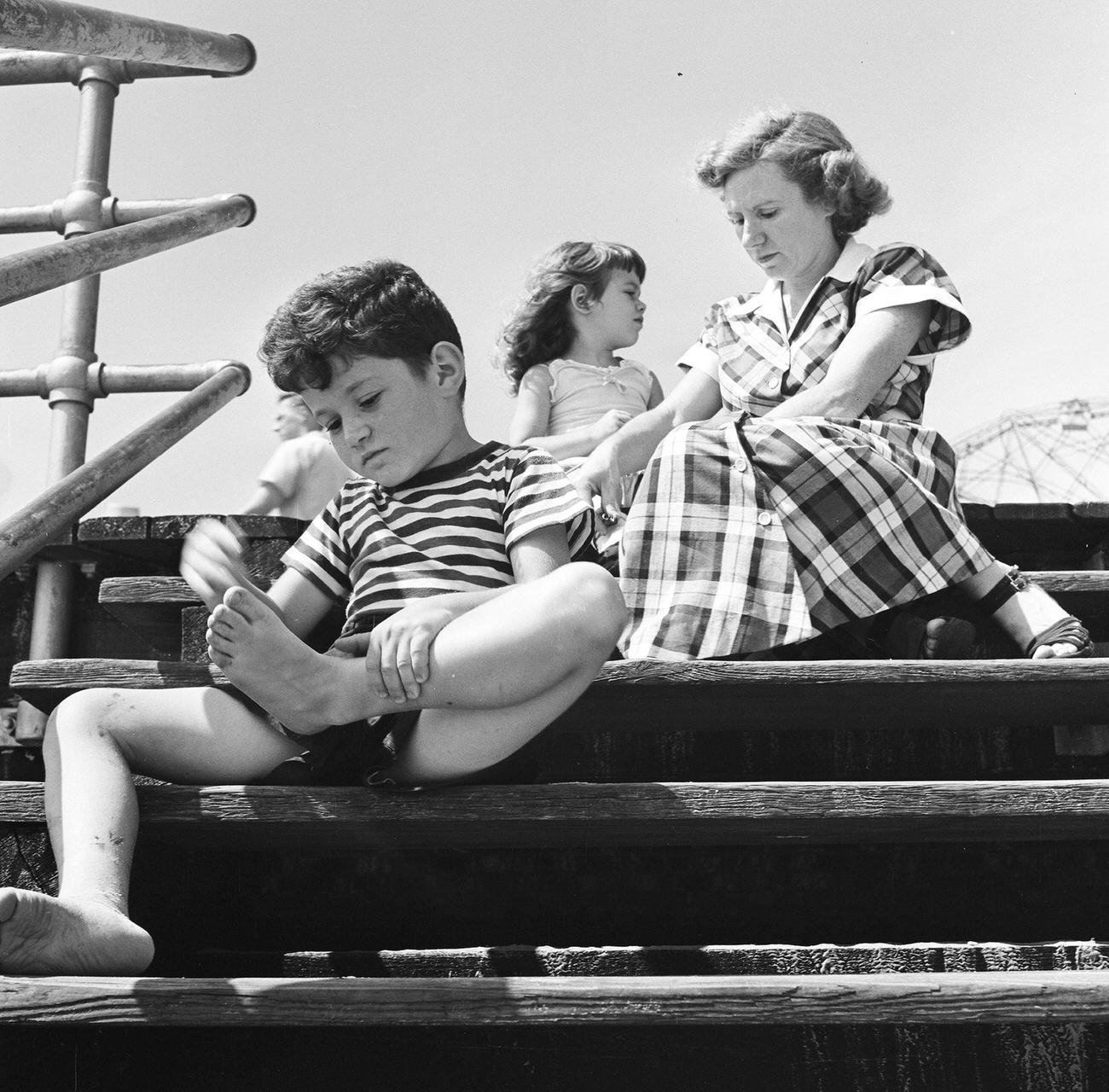 Boy Wipes Sand Off Feet On Coney Island Boardwalk, 1948