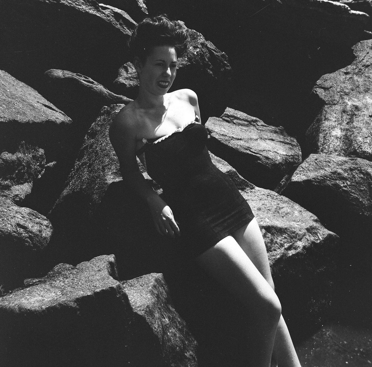 Young Woman Leaning Against Large Rock On The Beach, 1944