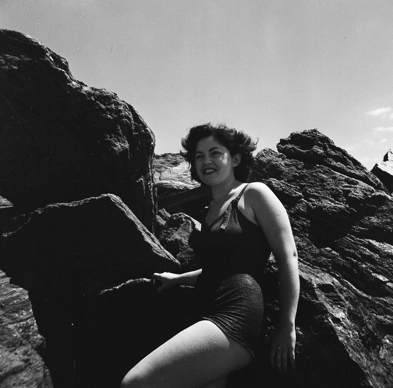 Woman Leaning Against Large Rock On Beach, 1944