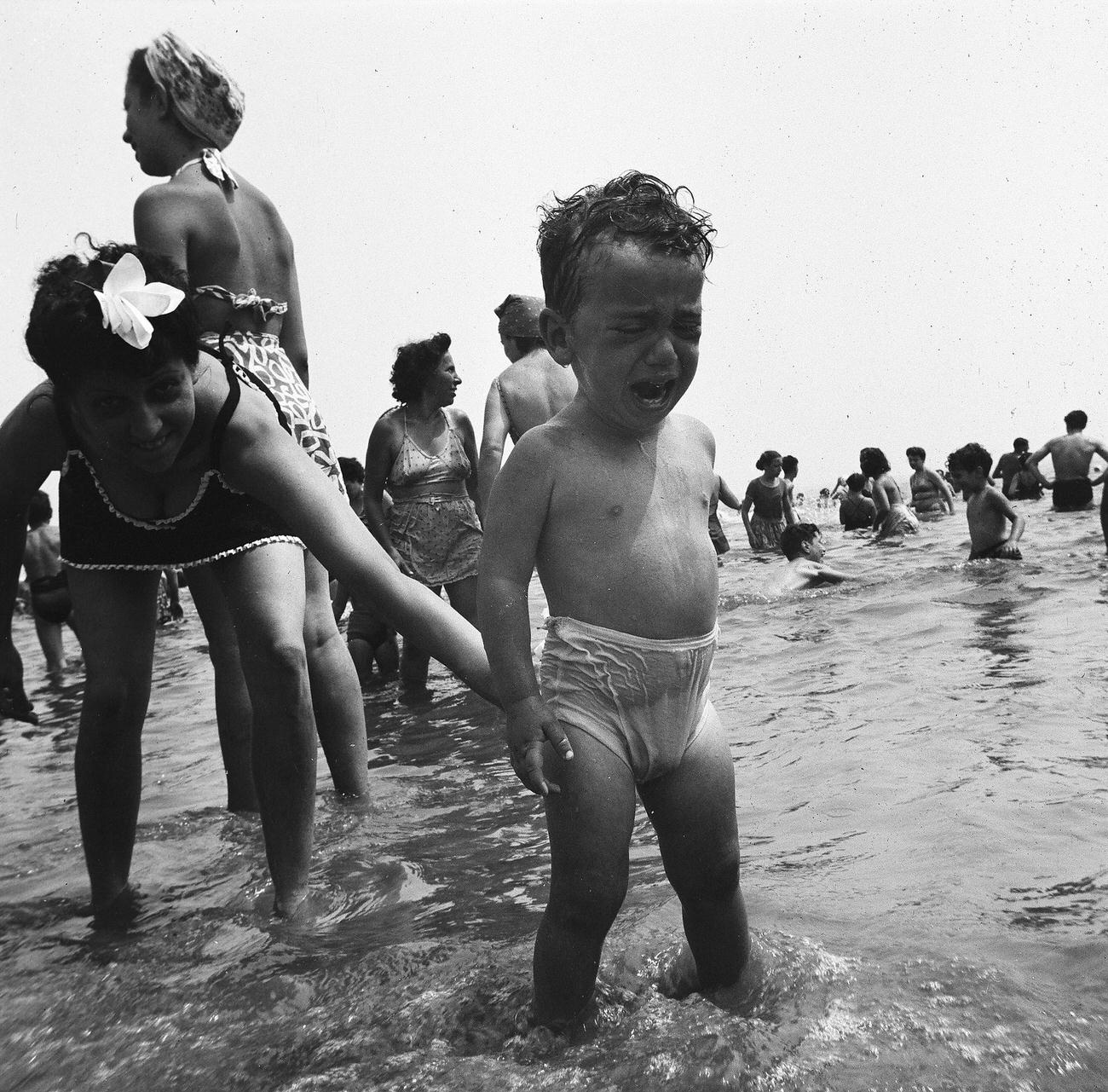 Woman Bends Down To Crying Boy In Ankle-Deep Water, 1944