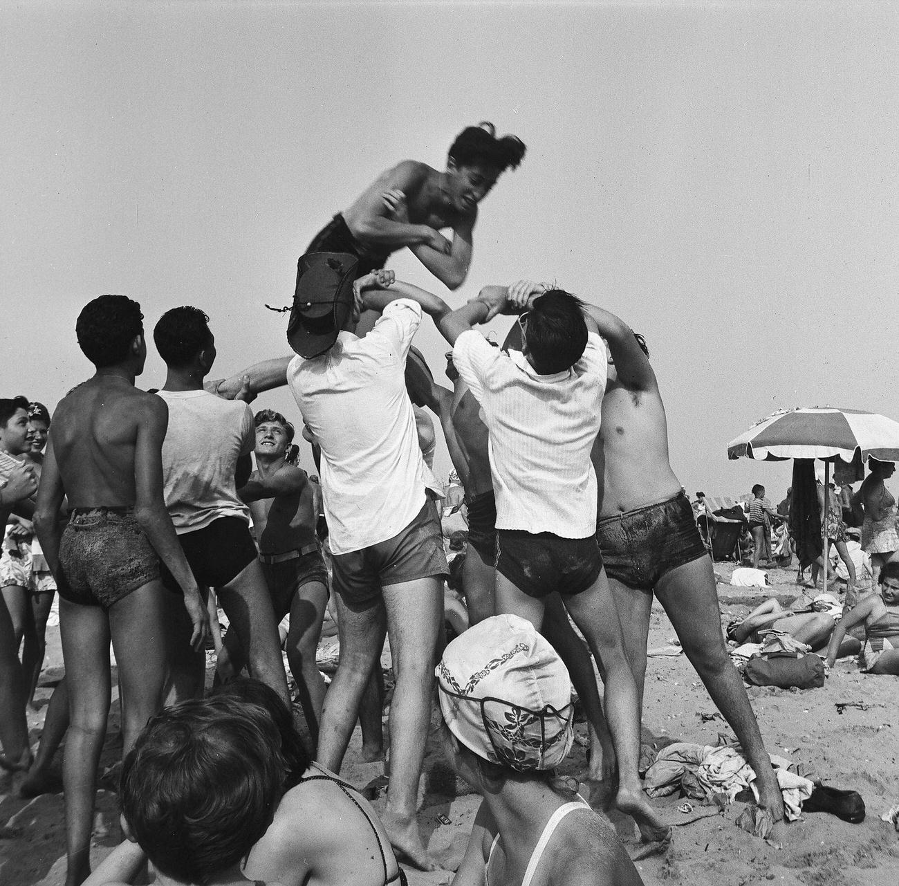 Men Tossing A Friend Into The Air At Coney Island Beach, 1944