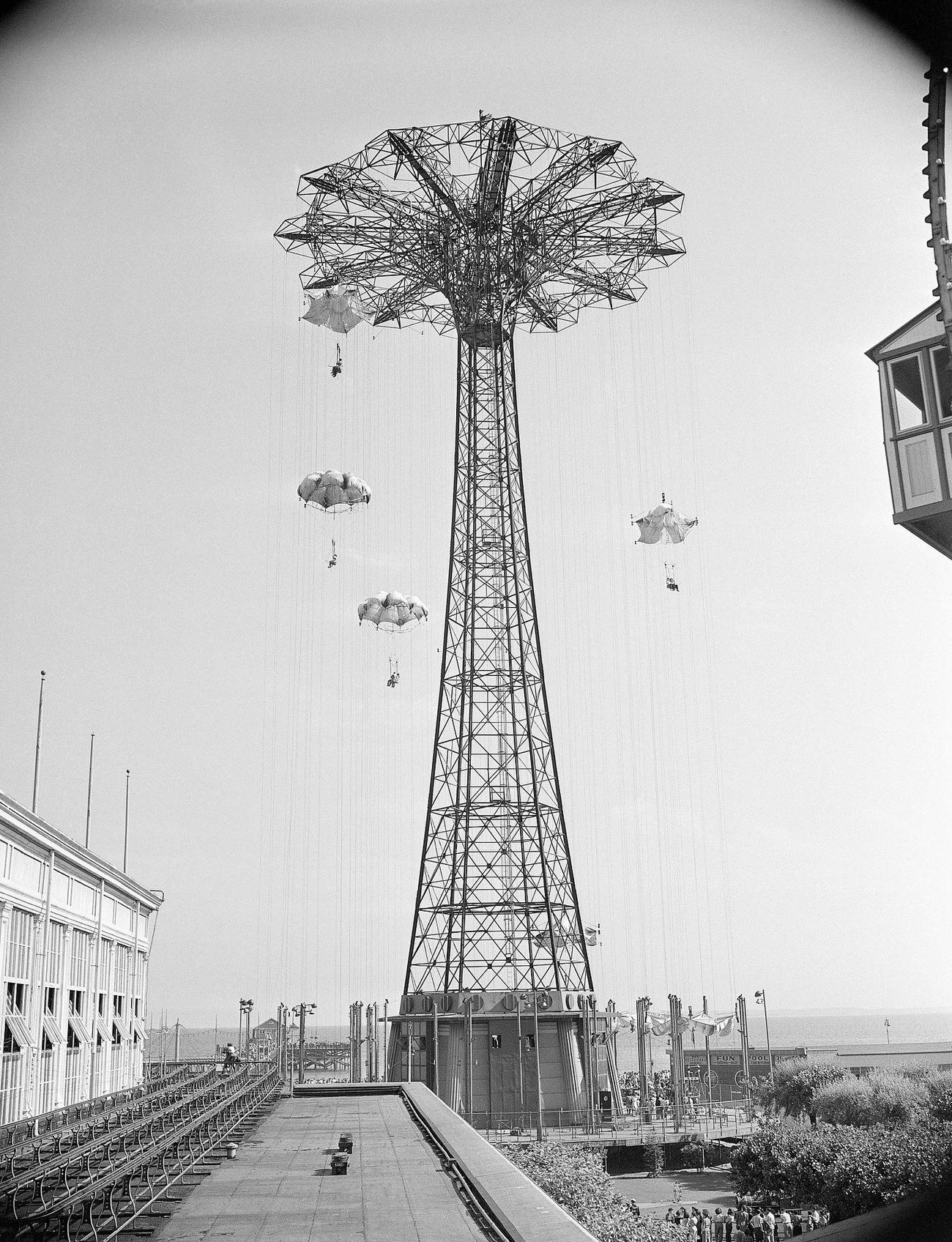 Visitors Enjoy The Parachute And Steeple Chase Rides At Coney Island