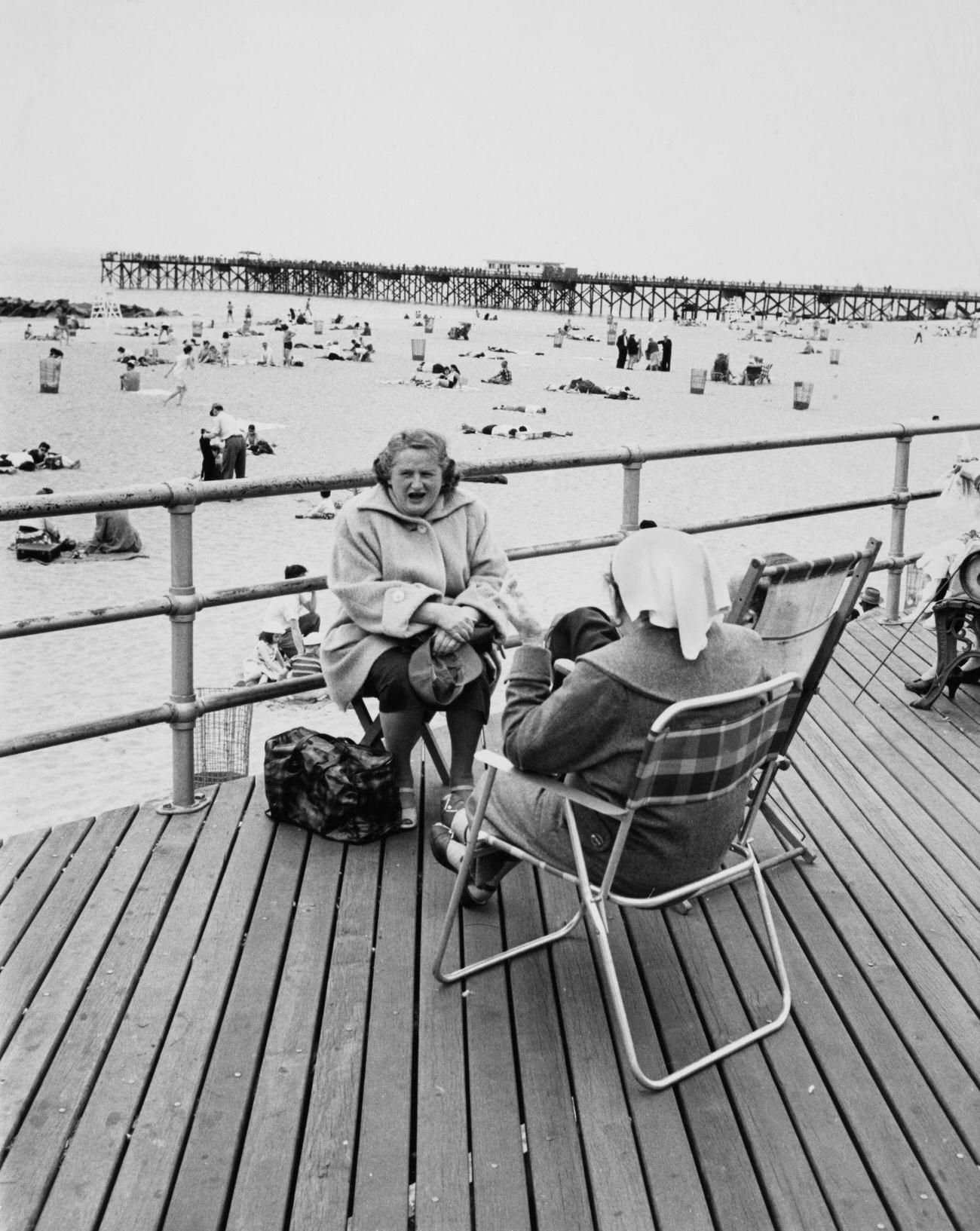 Women In Coats On Boardwalk Contrasting With Swimmers, May 1959