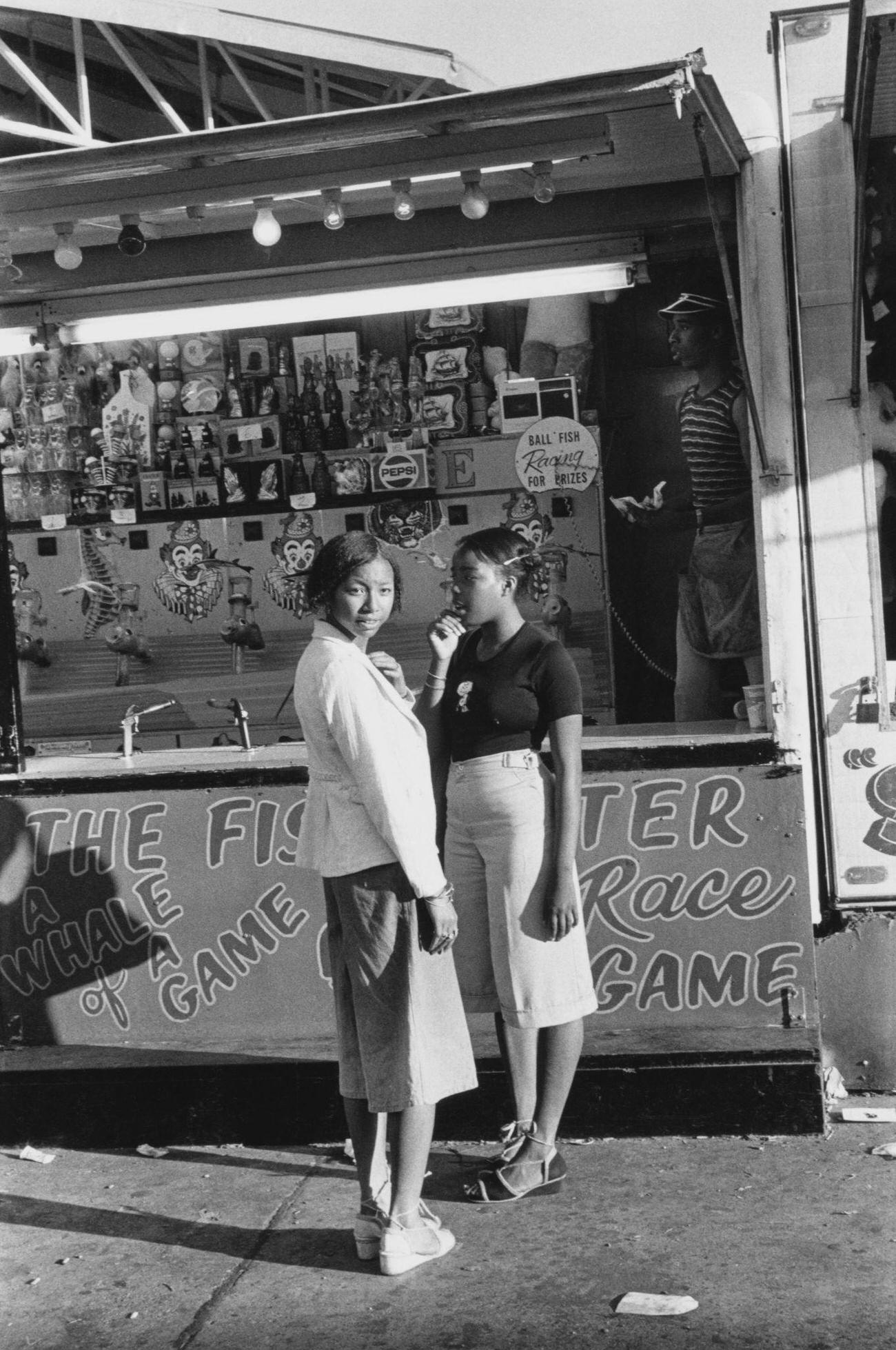 Two Young Women Standing Outside An Attraction At Coney Island, Circa 1975