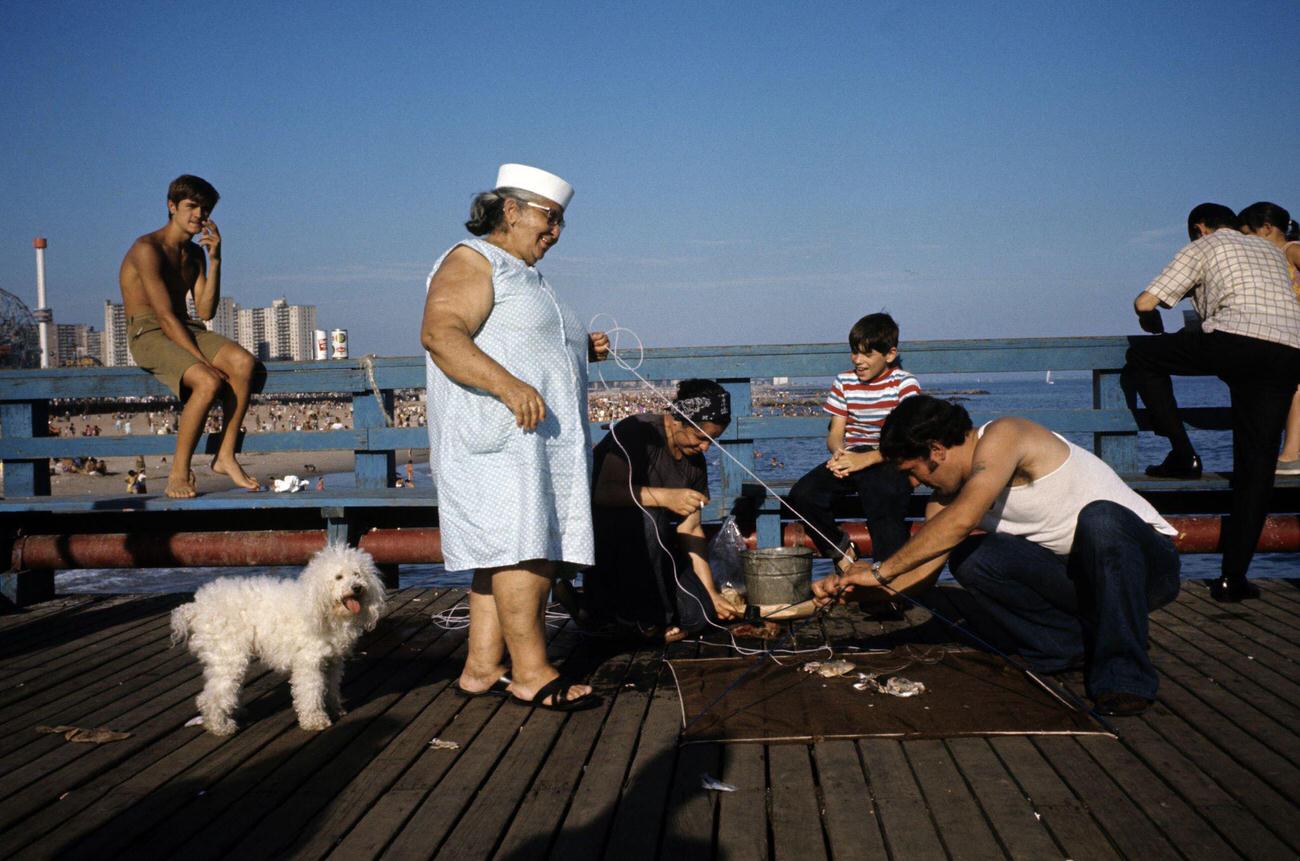 People With A White Poodle Preparing To Fish At Coney Island, 1971