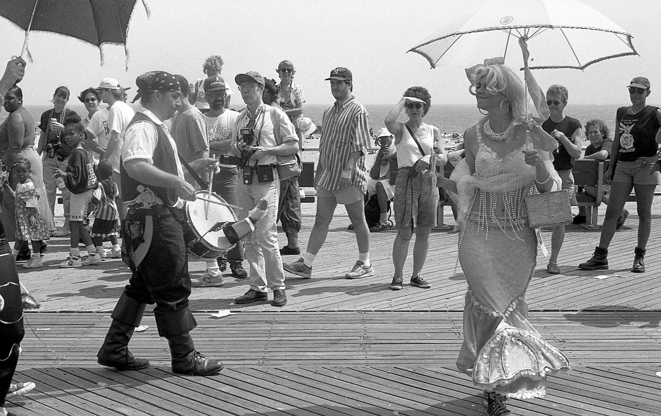Mermaid Dances With Pirate Drummer At The Coney Island Mermaid Parade, 1994