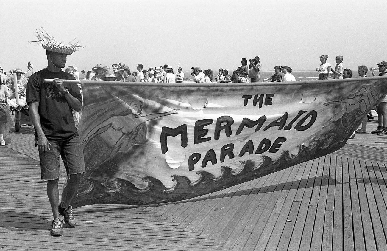 Man Carries Mermaid Parade Banner At Coney Island, 1994