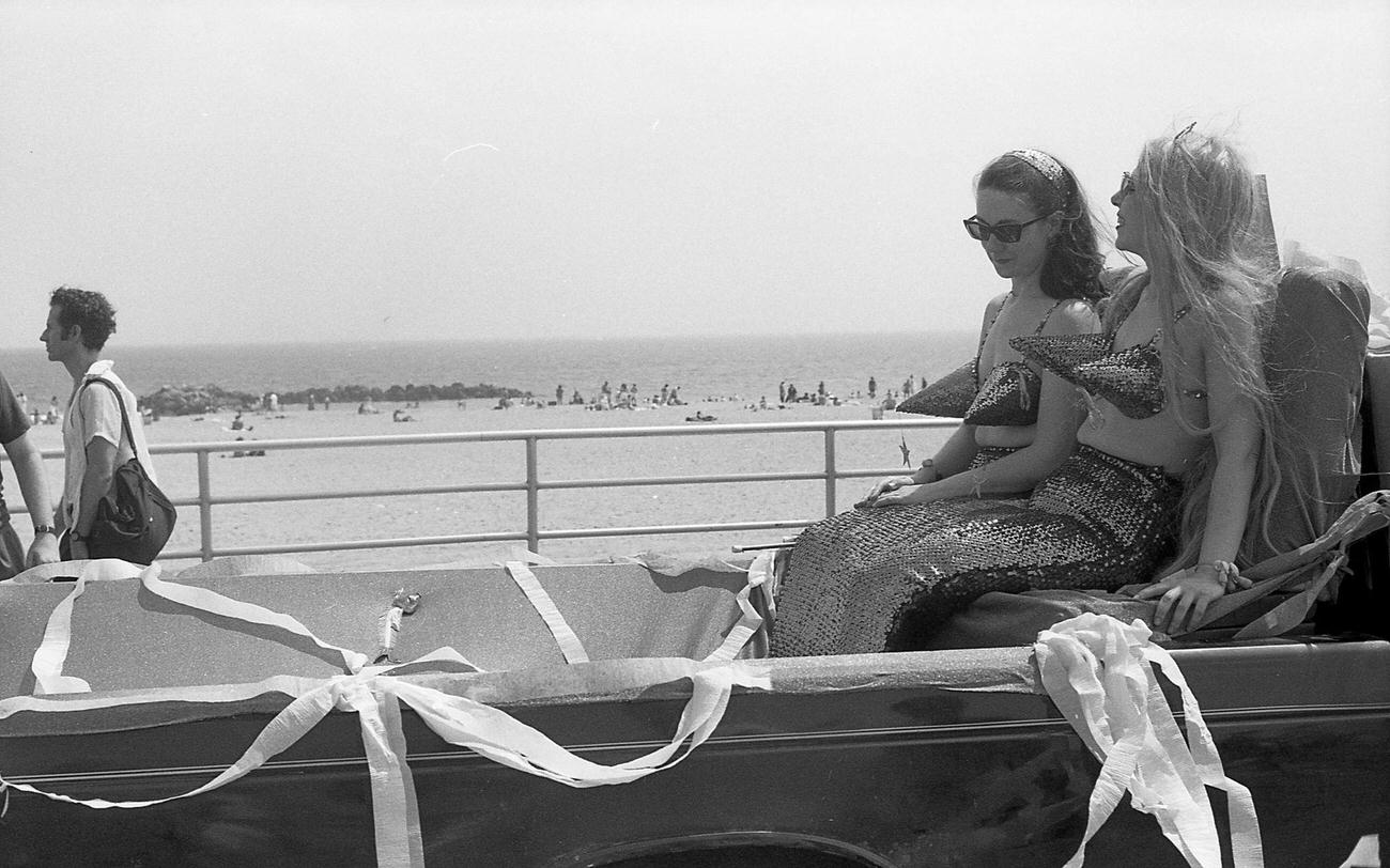 Two Mermaids Ride A Vehicle At The Coney Island Mermaid Parade, 1994
