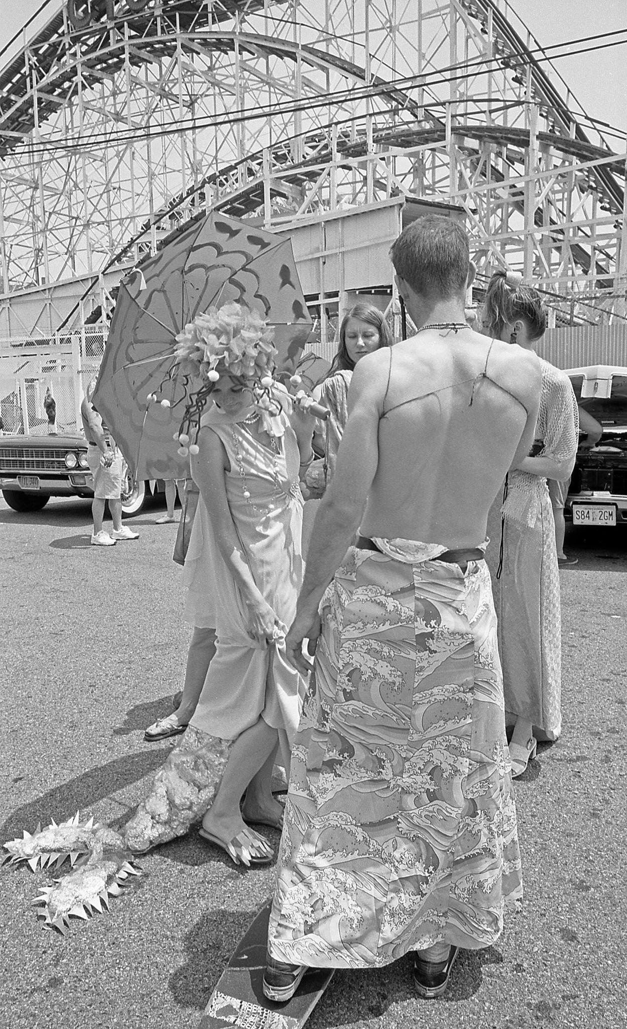 People In Mermaid Costumes Stand In Front Of Cyclone At Coney Island Mermaid Parade, 1997