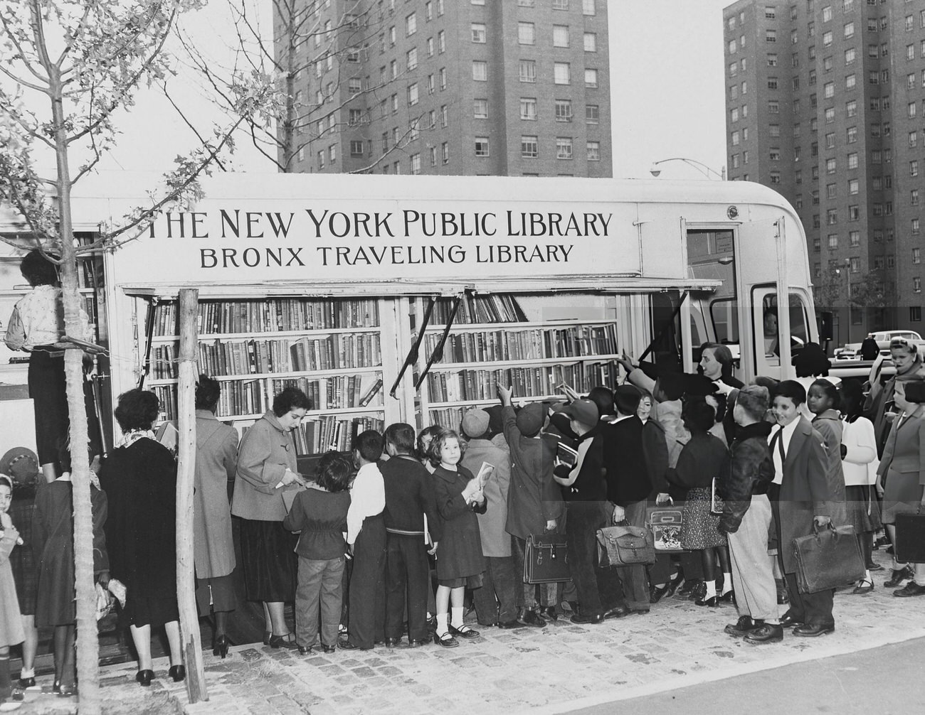 A Large Group Of Children And Adults Gather At The Bronx Traveling Library Bookmobile In New York City, 1954.