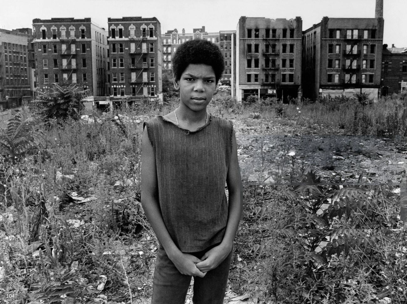 A Young Man Stands In A Vacant Lot In The South Bronx With Abandoned Buildings Behind Him, 1977.