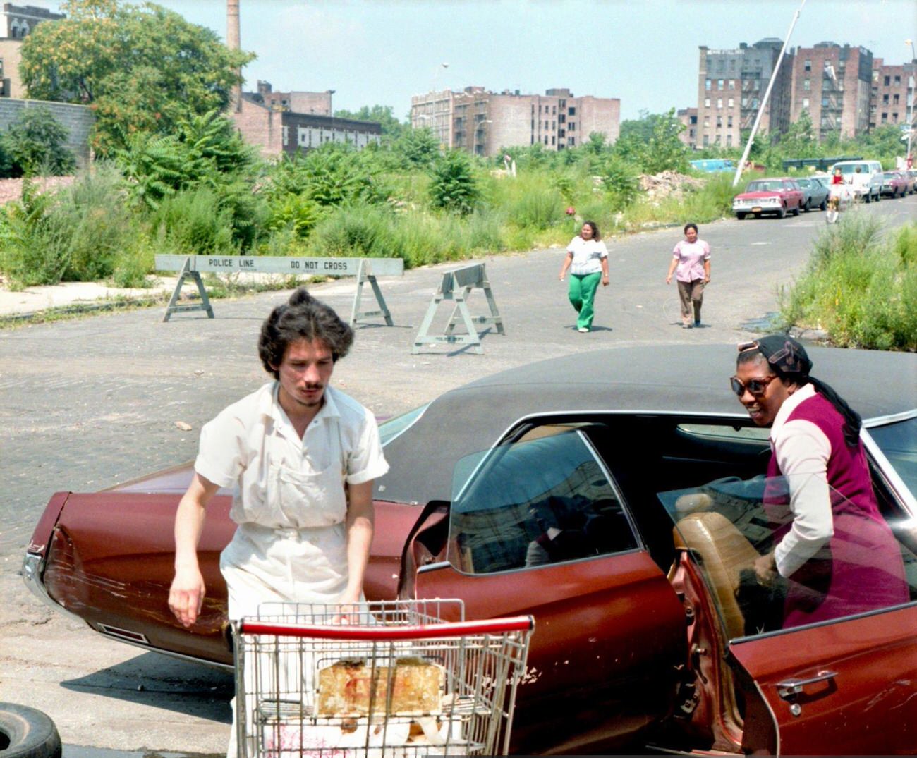 A Shop Worker Helps A Woman Load Groceries Into A Car In The South Bronx, August 1980.