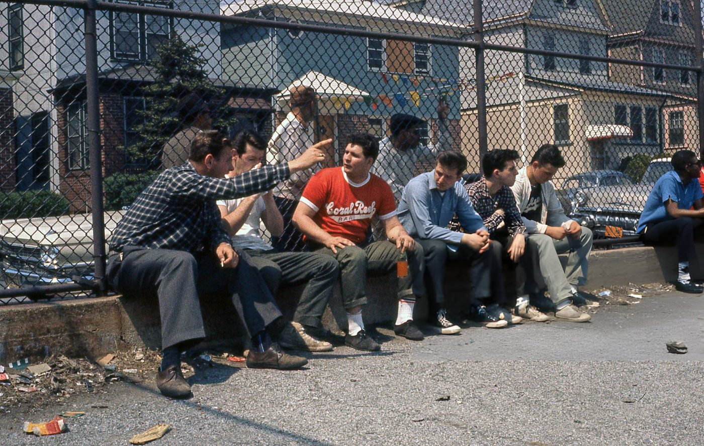 Unidentified Men Talk, Leaning Against A Chain-Link Fence In The Ps 143 (Later Named Ps 143 Louis Armstrong) Yard In Corona, 1960S.