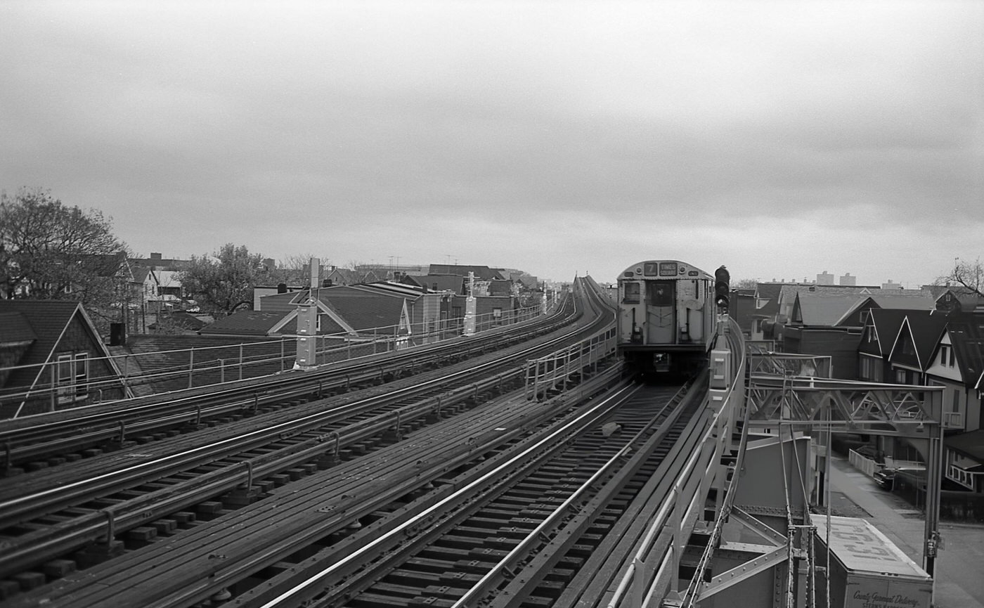 The Number Seven Train Travels Along The Elevated Subway Tracks Through A Residential Neighborhood In Corona, Queens, 1974.
