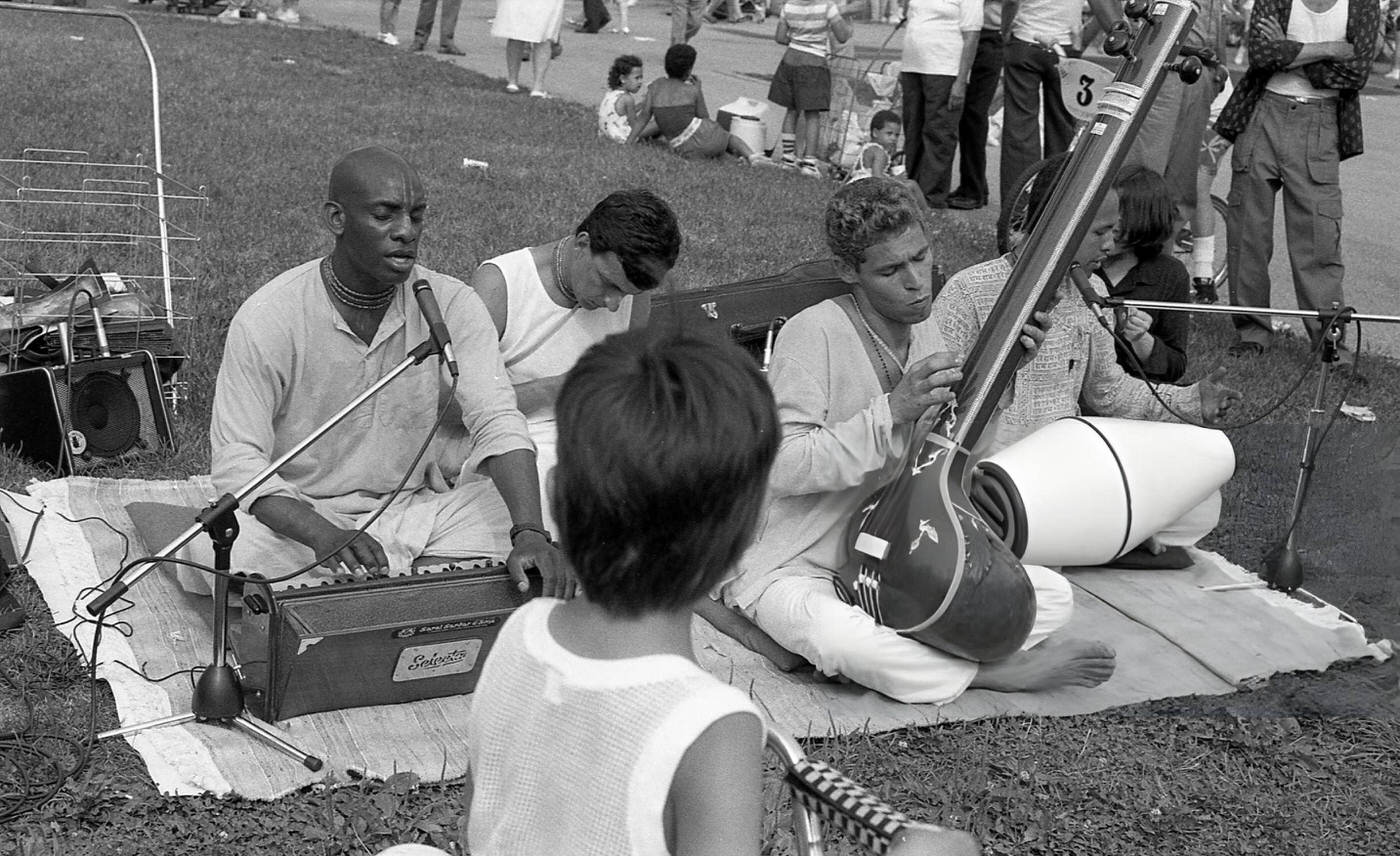 A boy on a bicycle stops to watch musicians perform traditional Hindustani music in Flushing Meadows Park, Corona, Queens, 1988.