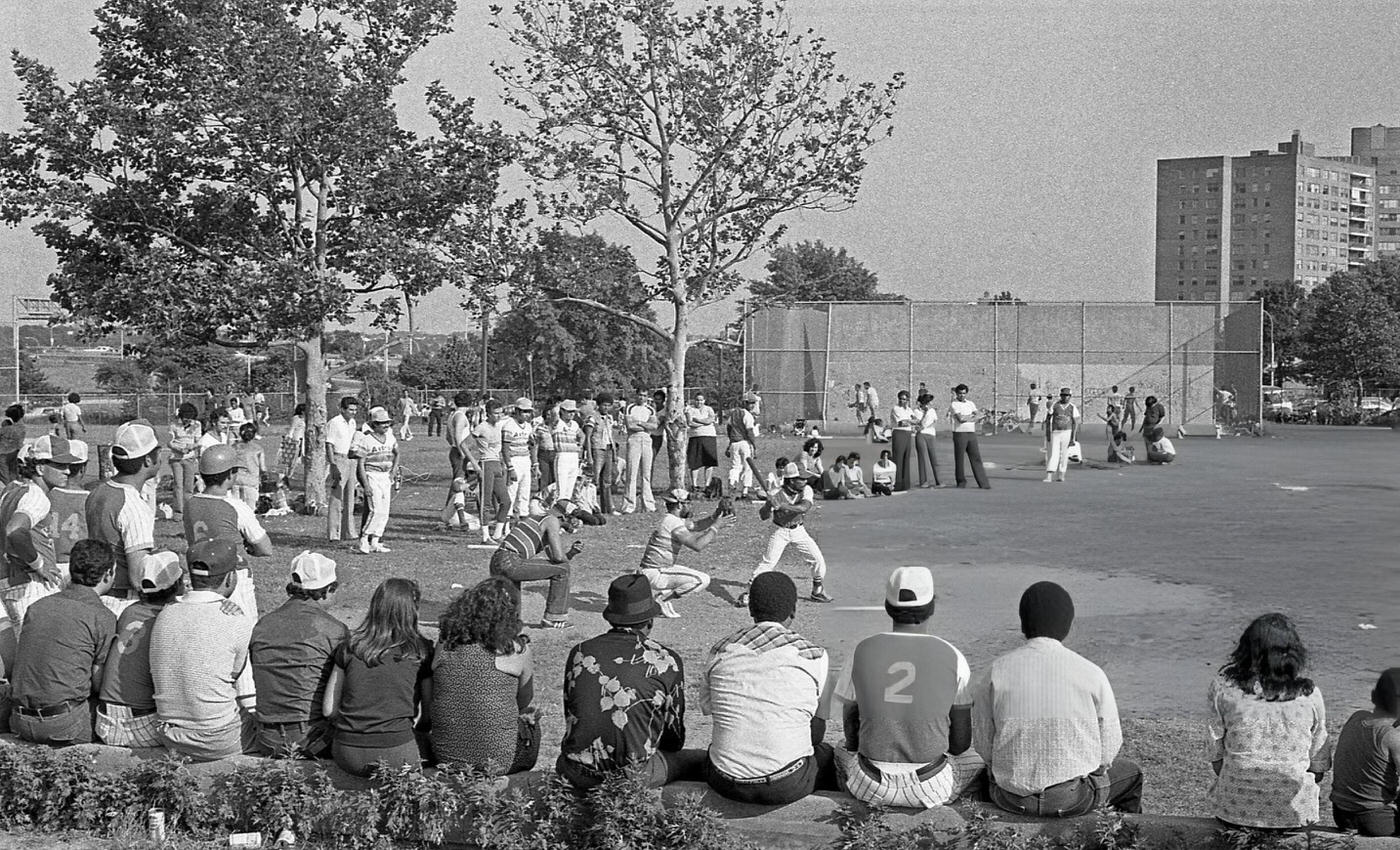 Players and spectators watch a baseball game in Flushing Meadows Park, Corona, Queens, 1980.