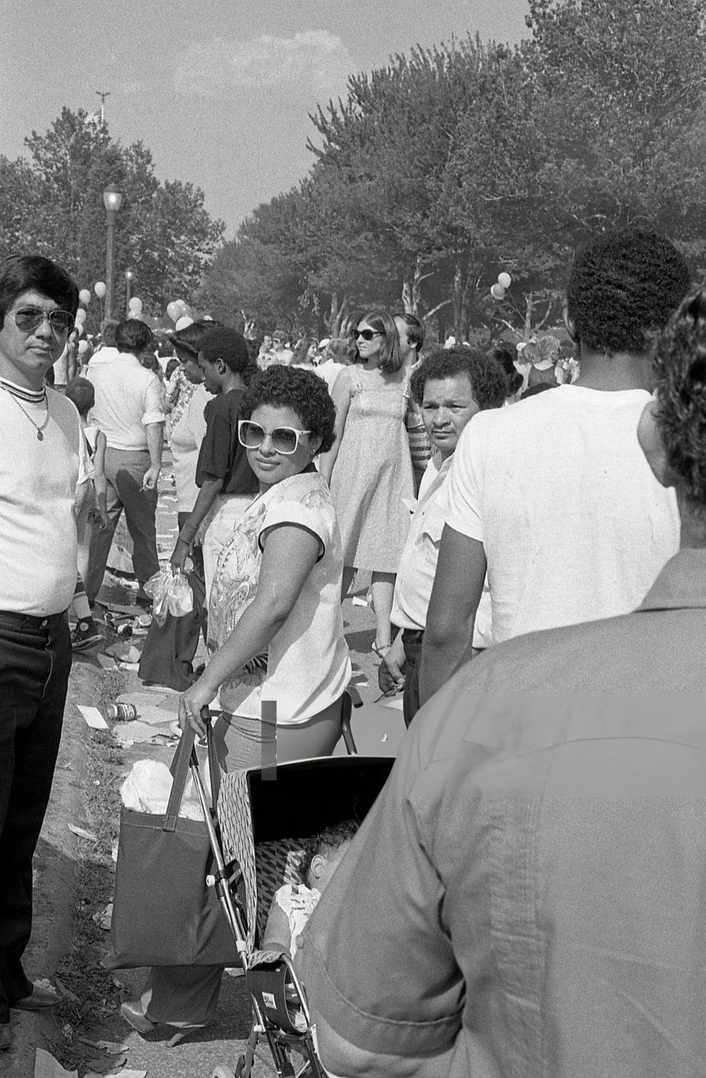 People crowd on a footpath in Flushing Meadows Park, Corona, Queens, 1980.