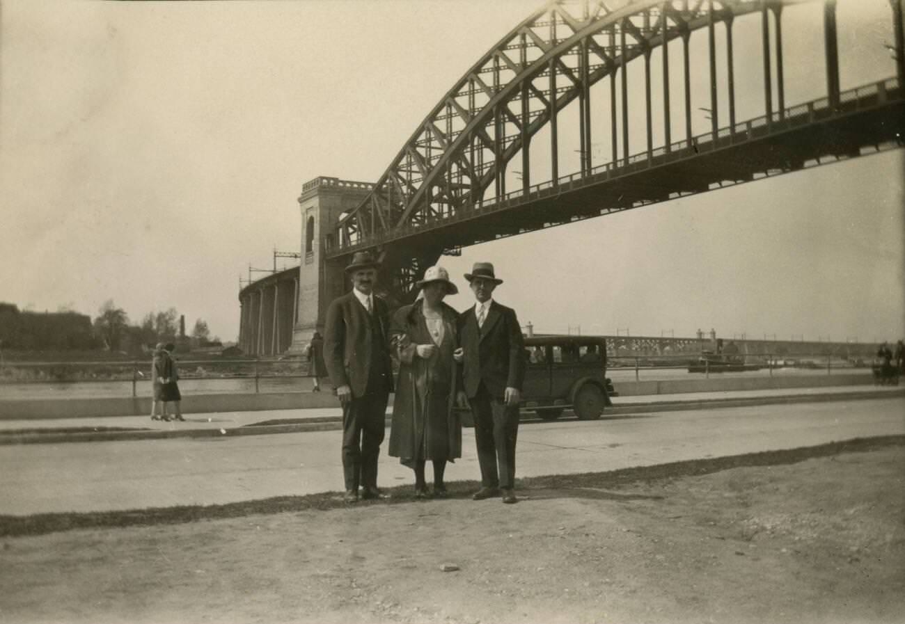 A Family Poses In Front Of The Hell Gate Bridge, A Steel Through Arch Railroad Bridge In New York City, Crossing The Hell Gate, 1920.
