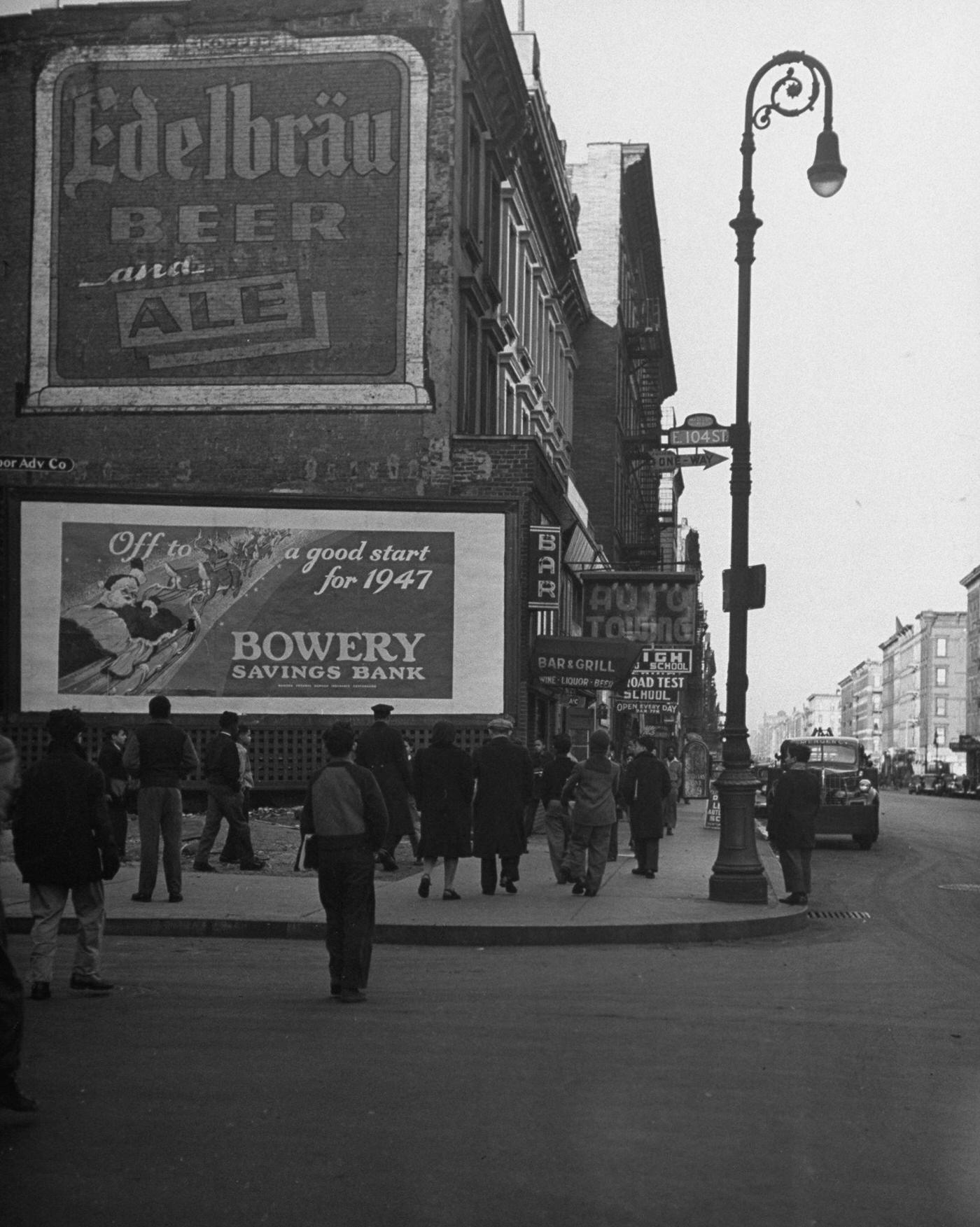 People Walking Past Billboards On A Street In East Harlem, Manhattan, 1947