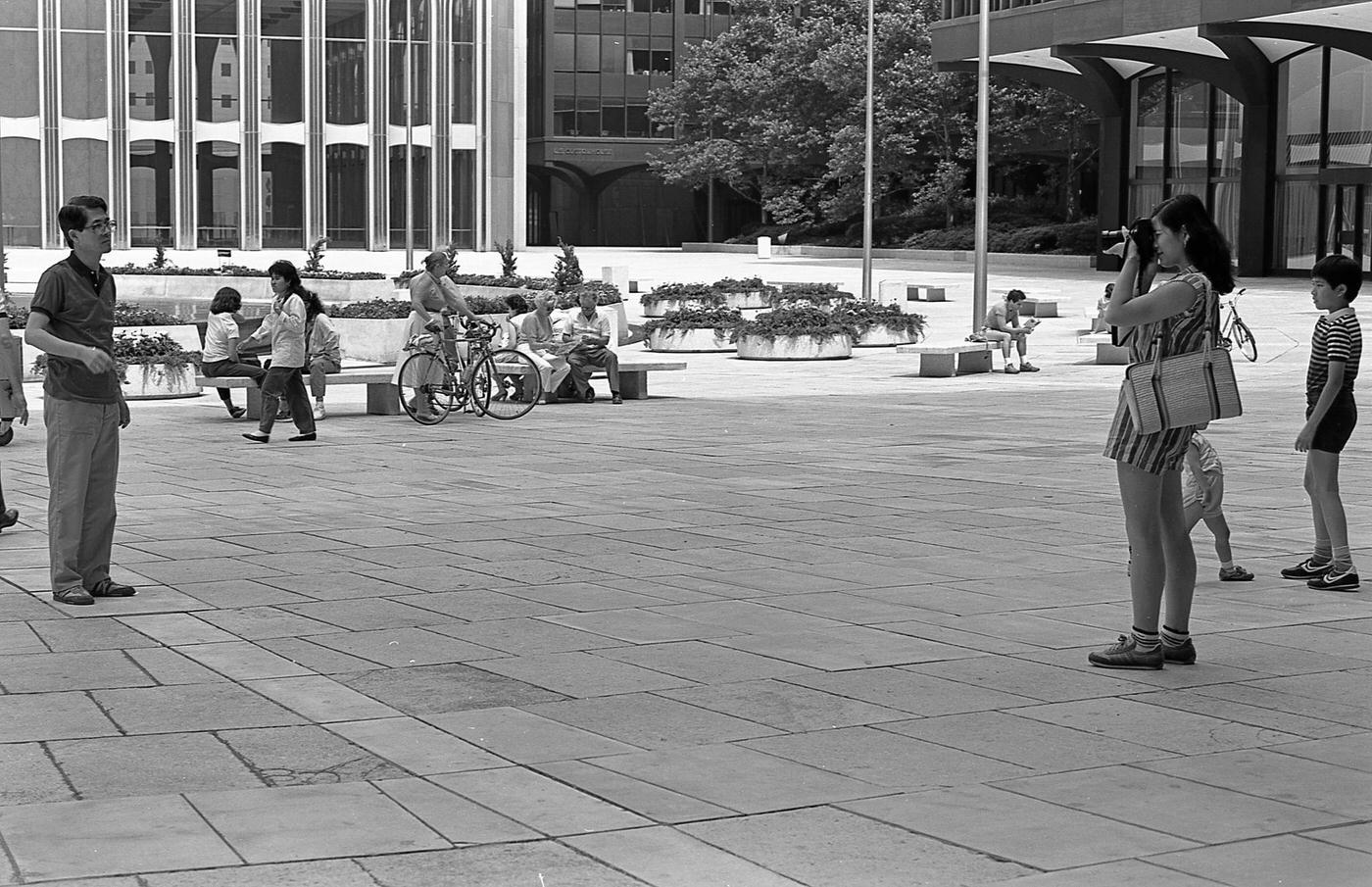 Woman Taking A Photograph At World Trade Center Plaza, Lower Manhattan, 1985