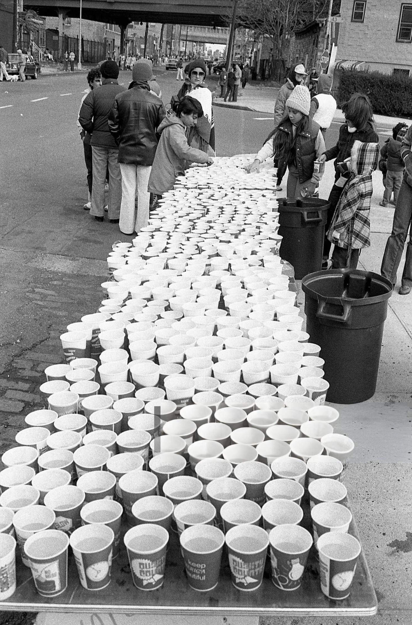 Volunteers At A Water Station Place Filled Cups On Folding Tables At The 14-Mile Marker On Crescent Street During The New York City Marathon, Queens, 1980.