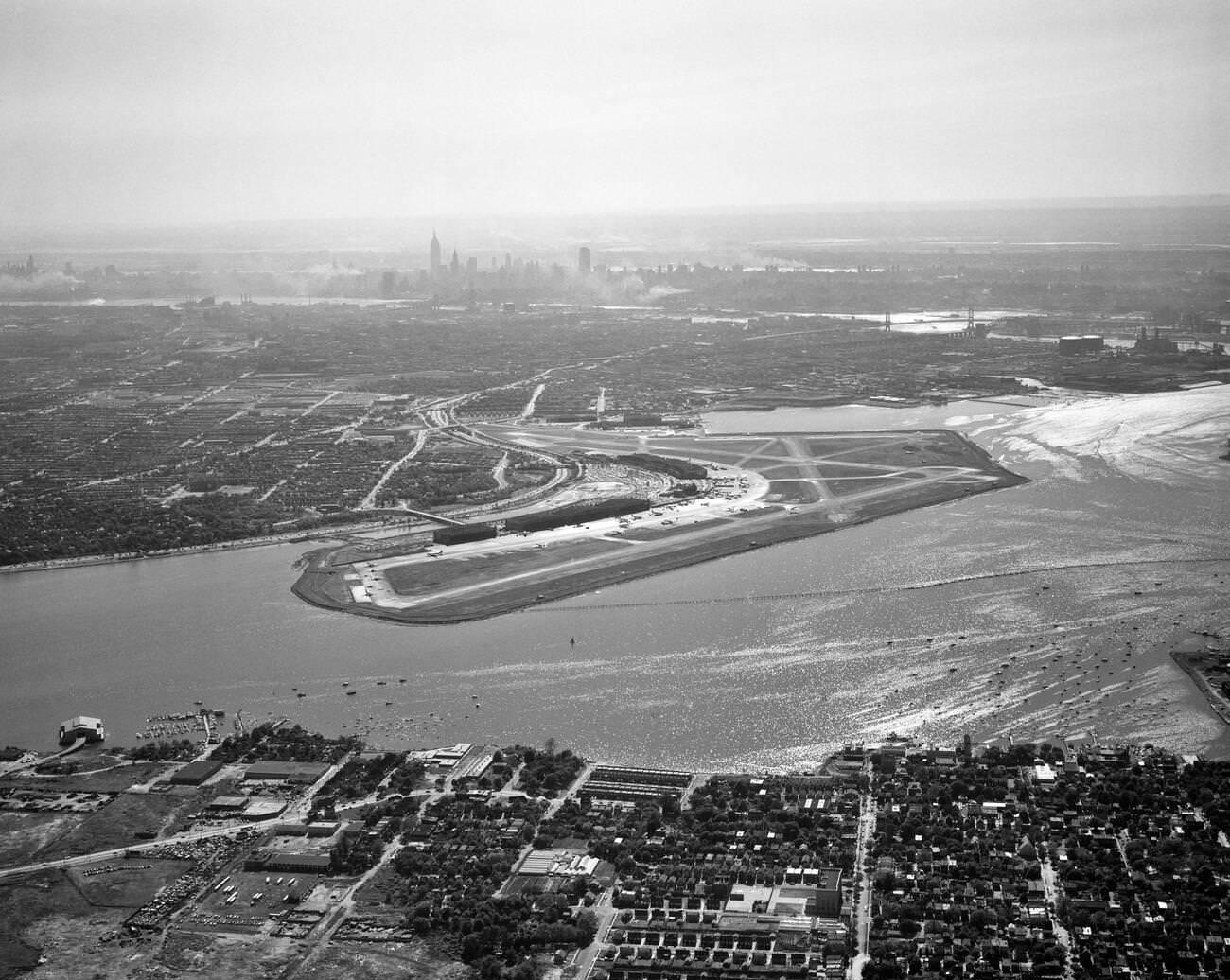 An Aerial View Across Flushing Bay To Laguardia Airport, College Point, Queens, And The Manhattan Skyline In The Distance, 1950S.