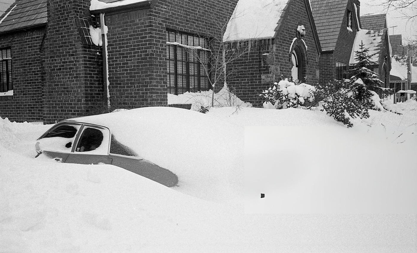 A Vehicle Sits Completely Buried Under Deep Snow In The Driveway Of A Residential Home In Queens In The Aftermath Of The Blizzard Of 1978.