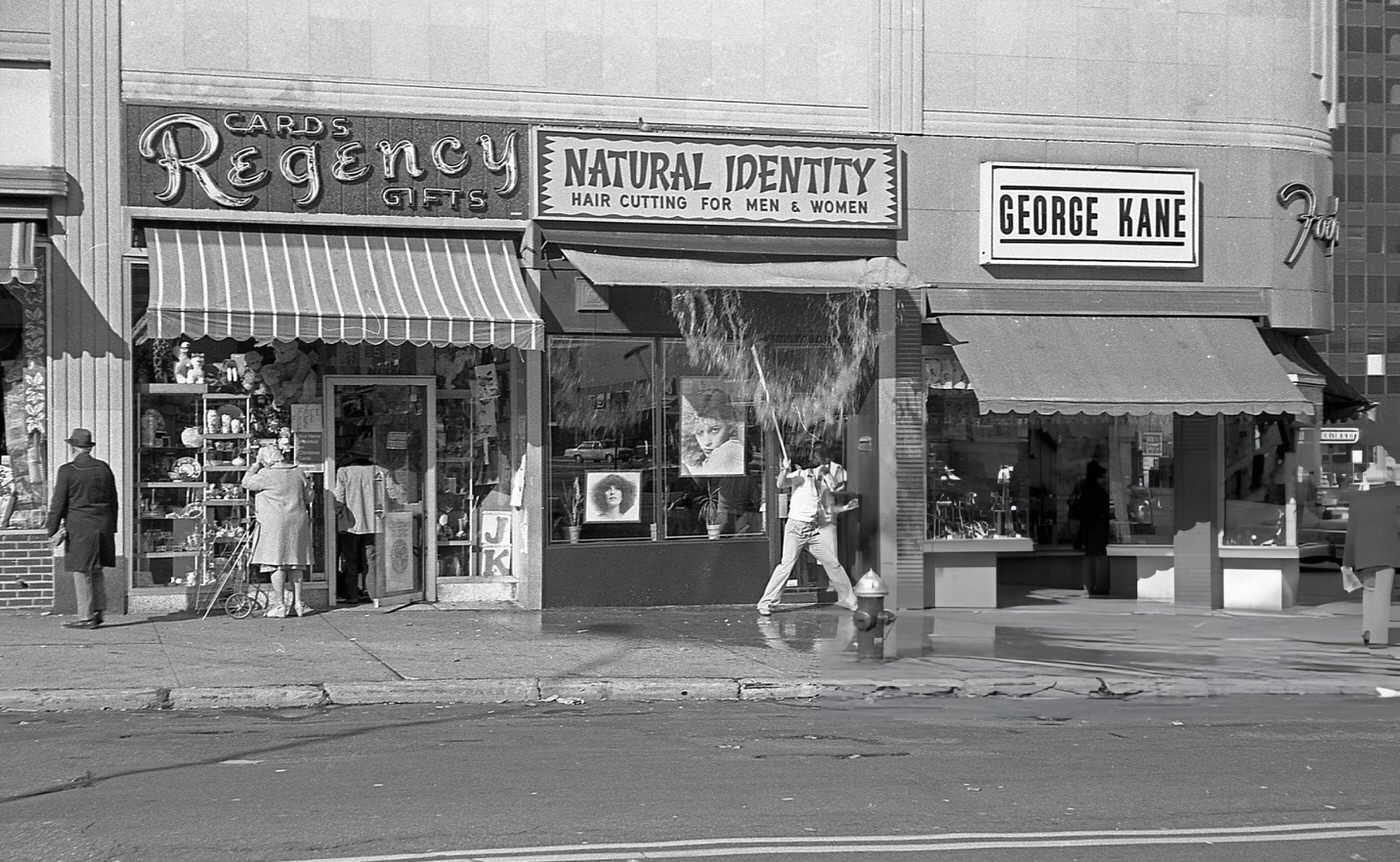 A Man Uses A Stick To Knock Water Off The Awning Of The Natural Identity Hair Salon On 63Rd Drive In Rego Park, Queens, 1978.