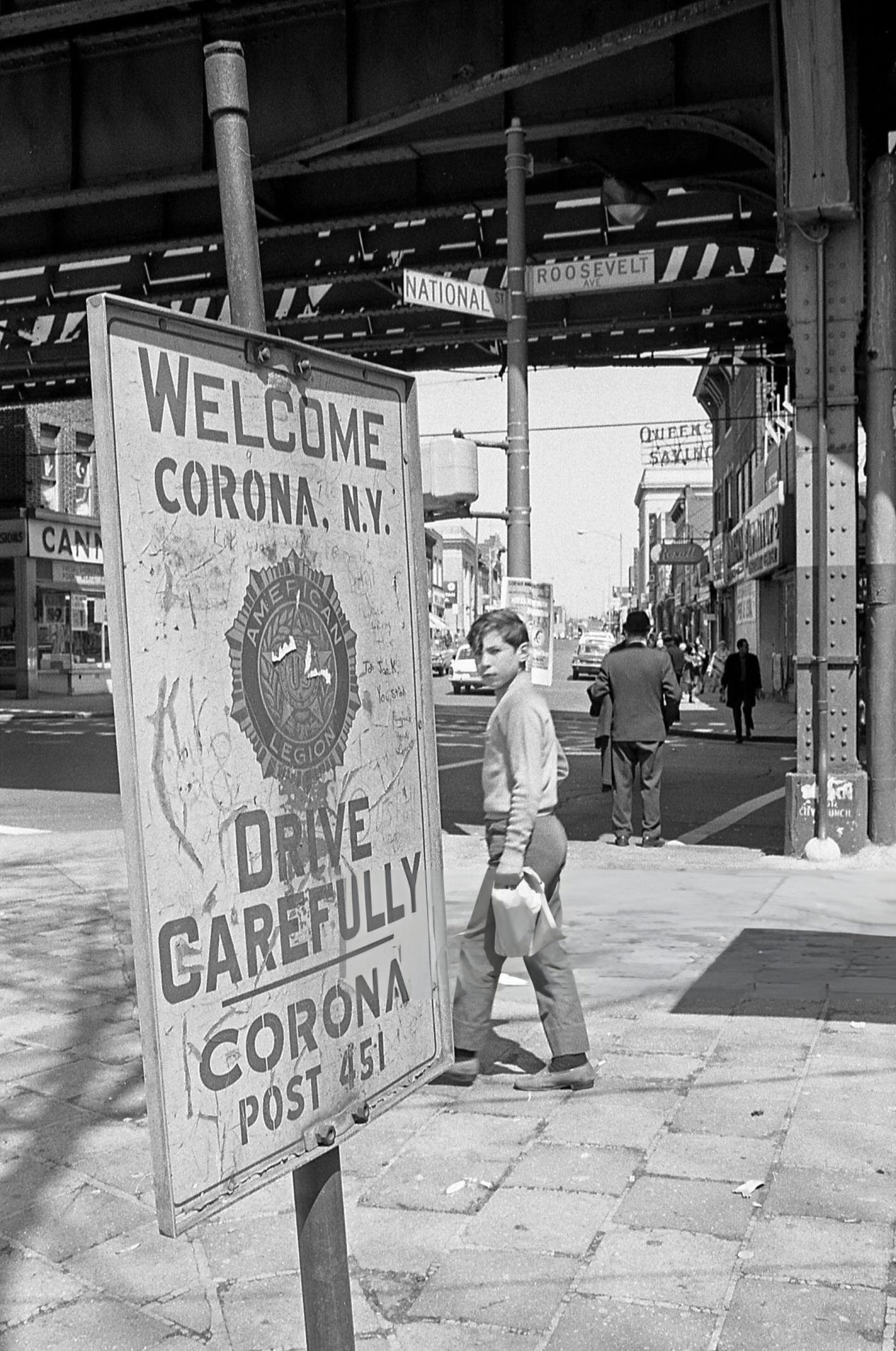 A Boy Walking Past A Street Sign On Roosevelt Avenue In Corona, Queens, 1970.