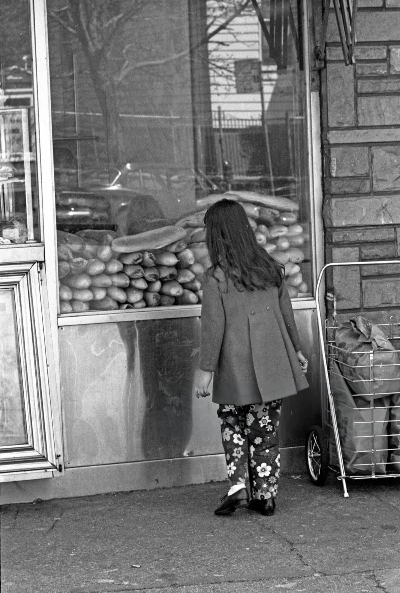 A Young Girl Looking At Loaves Of Italian Bread Through The Window Of A Bakery Shop On 108Th Street In Queens' Corona Neighborhood, 1970S.