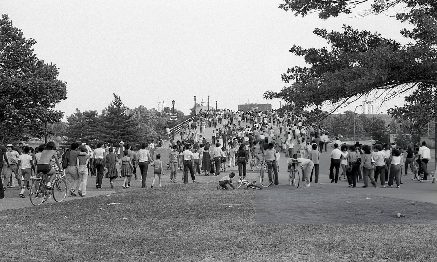 People Walk Over A Pedestrian Bridge In Flushing Meadows Park, Corona, Queens, 1980.