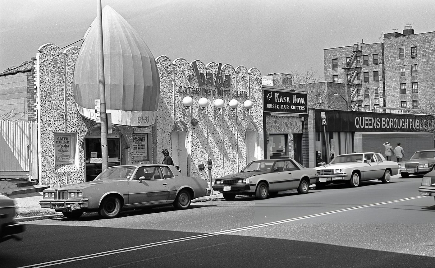 Businesses On 63Rd Drive In Rego Park, Queens, Including Baba Catering And Nite Club, Kasa Nova Unisex Hair Cutters, And A Branch Of The Queens Borough Public Library, 1984.