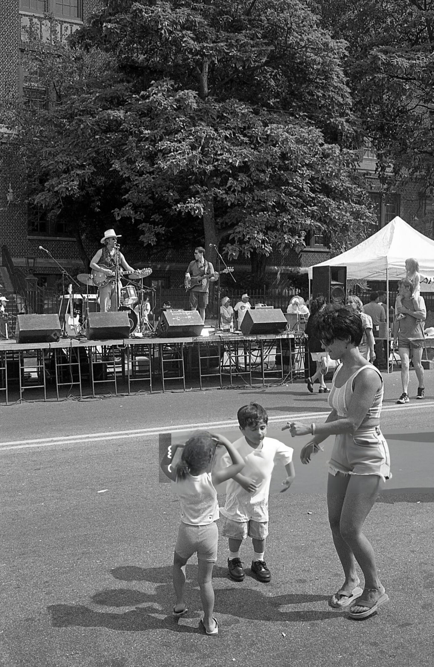 A Woman Dances With Two Children As A Band Performs On Stage During The 63Rd Drive Street Fair, Rego Park, Queens, 1997.