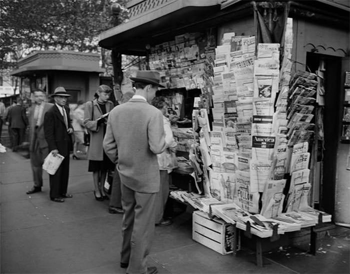 People Browsing Through Magazine Racks At A Busy Sidewalk Newsstand, 1947.