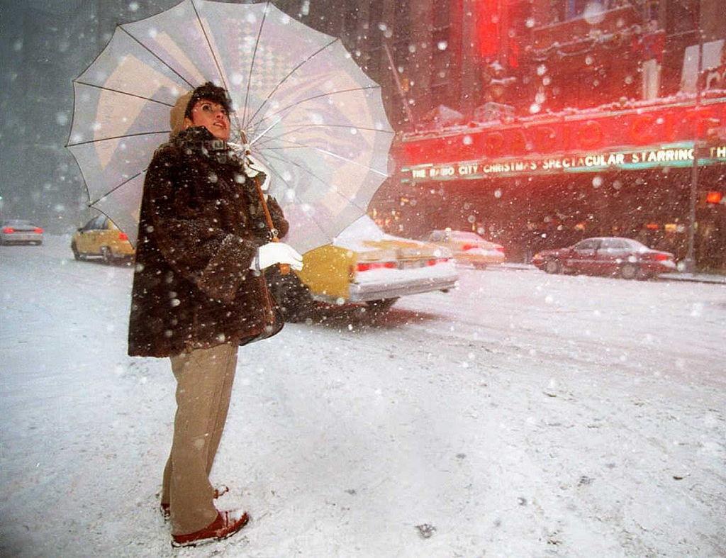 A Woman Looks Skyward As She Waits To Cross The Street Outside Radio City Music Hall, 1996