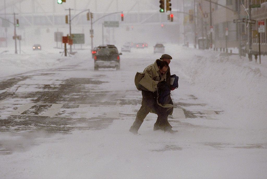 Pedestrians Struggle To Cross The Street During A Blizzard.