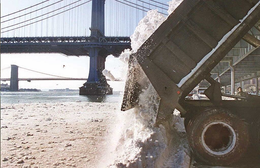 A New York City Department Of Sanitation Truck Dumps Snow Into The East River Underneath The Manhattan Bridge In New York With The Brooklyn Bridge Is Visible Behind, 1996