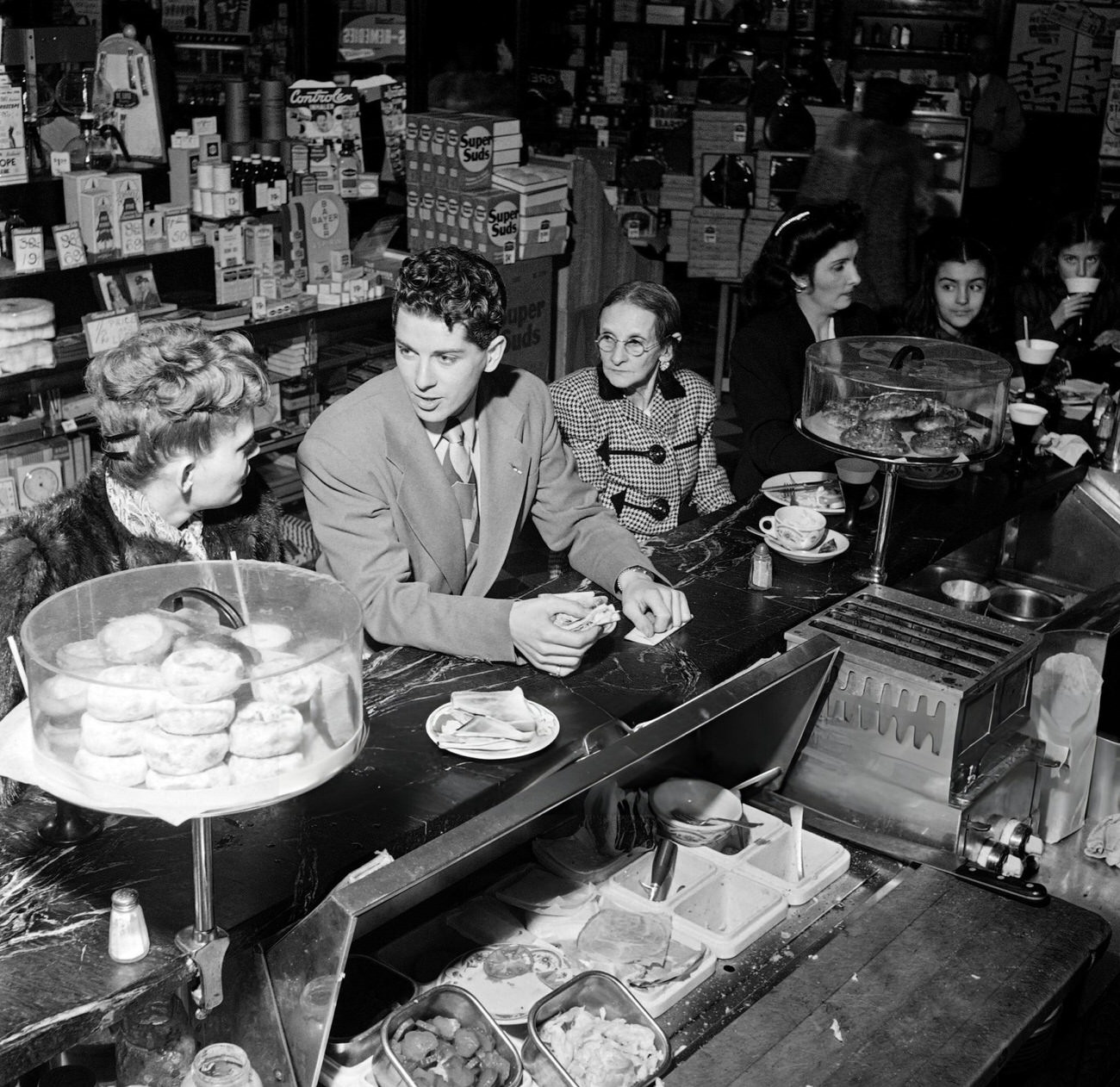 New Yorkers Speak Together In A Drugstore On Broadway, 1947.