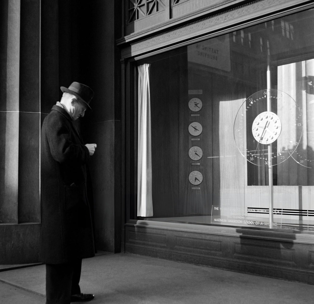 A Man Adjusts His Watch To The Clocks Displayed In The Telephone Building, 1947.