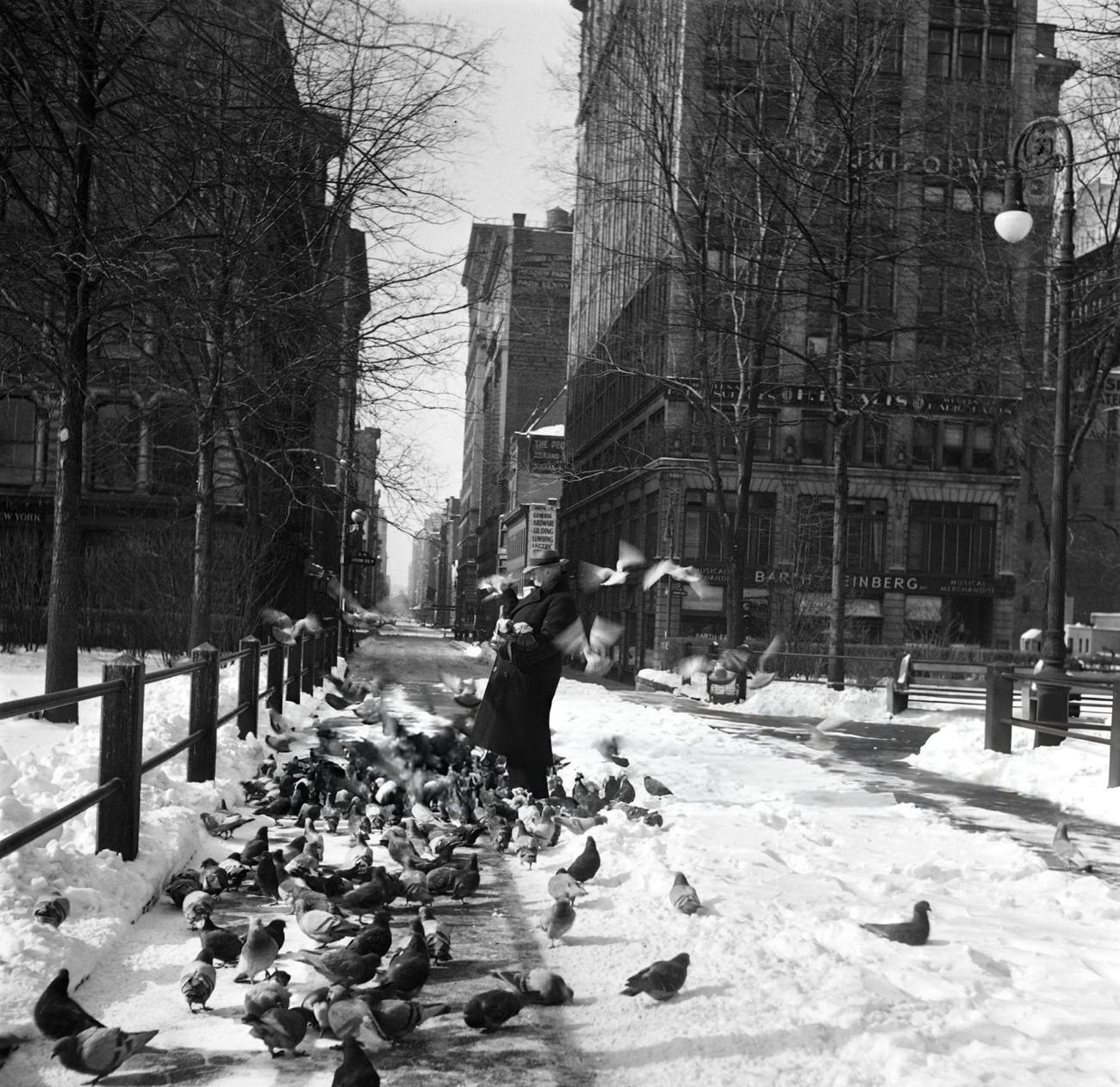 A Man Feeds Pigeons In Union Square Covered With Snow, 1947.