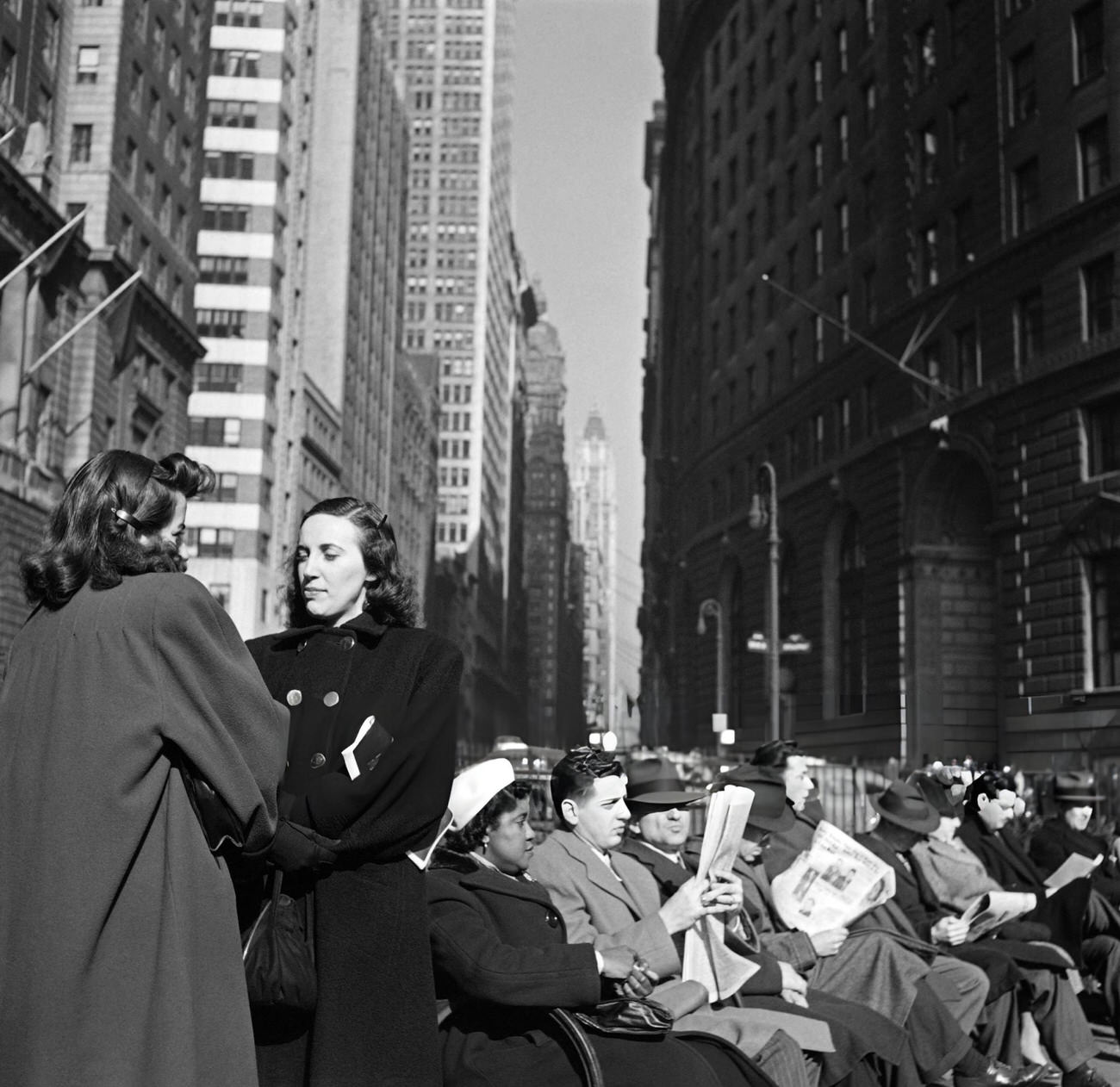 Two Women Talk Near People Sitting On The Benches Of Bowling Green Park, 1947.