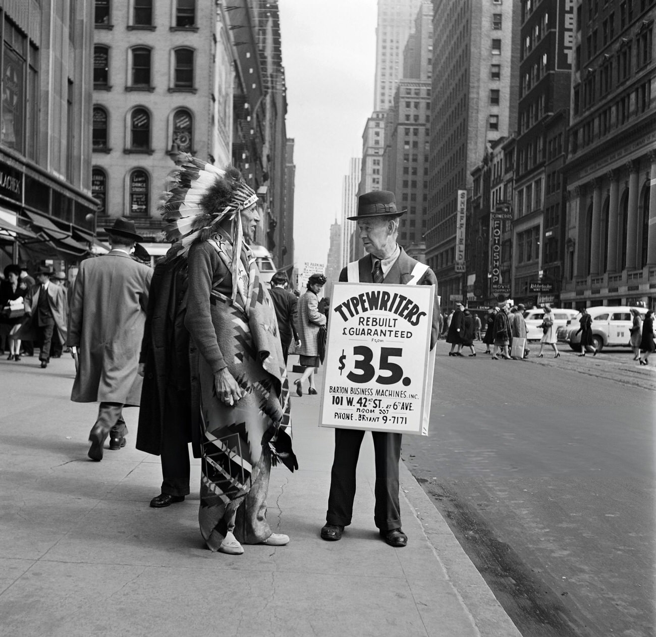 A Man Dressed As A Native American Chief Speaking With An Old Man Near Times Square On Broadway, New York, 1947.