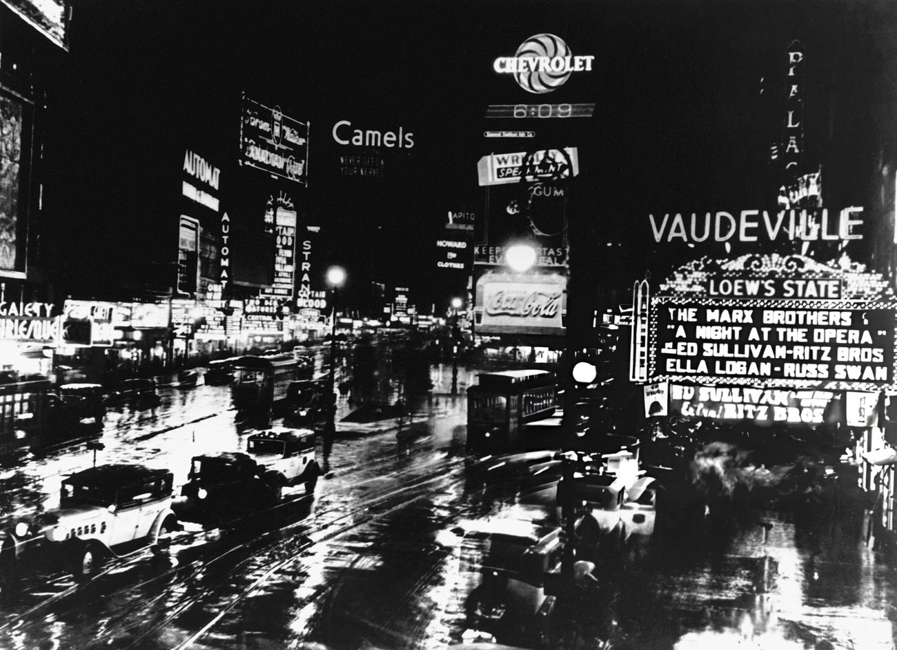 Times Square At Night Showing Lighted Signs, Automobiles, And Trolleys, 1940S.