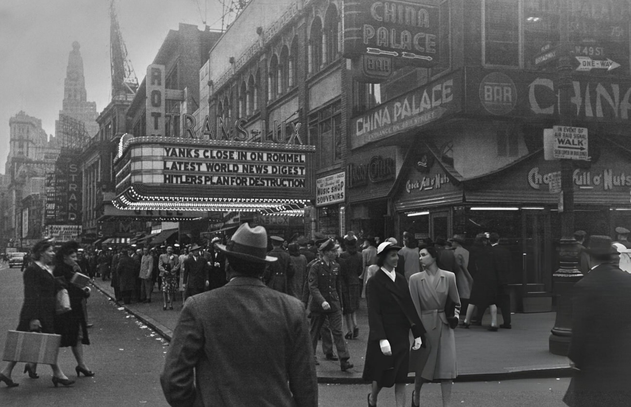 Pedestrians Walk Beneath The Marquee Of A Trans-Lux Theater In Times Square, Midtown Manhattan, New York City, 1943.