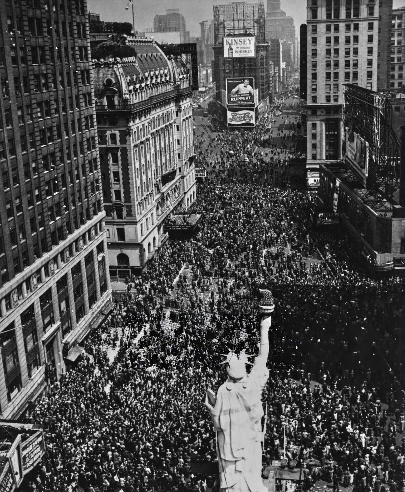 A High-Angle View Of Crowds Celebrating Victory In Europe Day, At The End Of The Second World War, With A Statue Of Liberty In The Foreground, In Times Square, Midtown Manhattan, 1945.