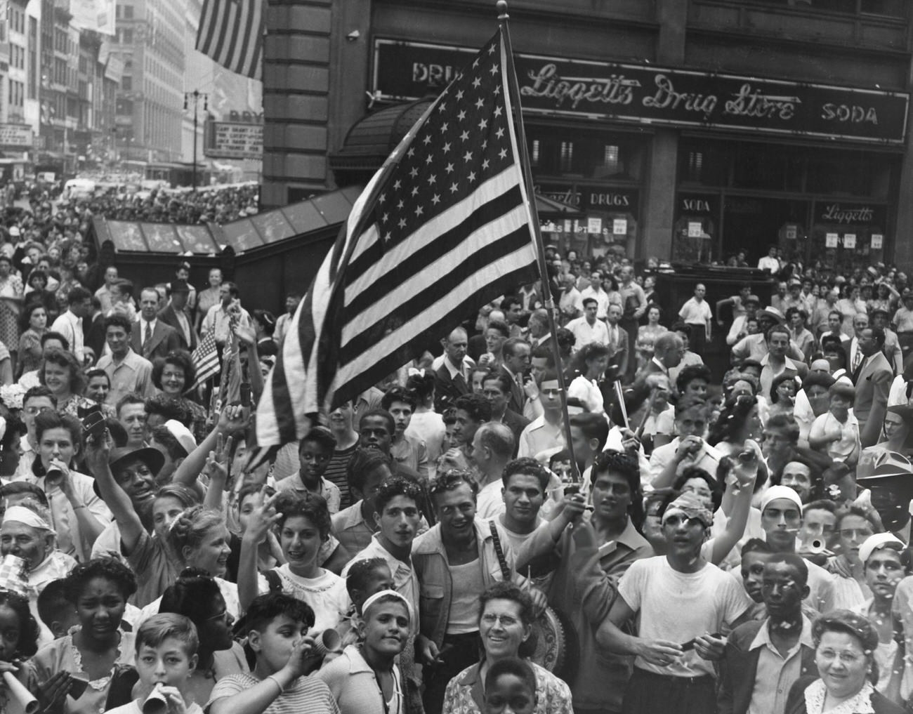 A Crowd Gathers To Celebrate Victory In Europe Outside A Branch Of Liggett'S Drug Store, 1945.