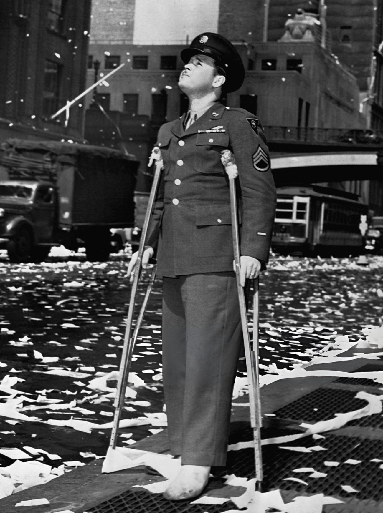 A Wounded U.s. Serviceman Watches New York City Celebrate Germany'S Unconditional Surrender, 1945.