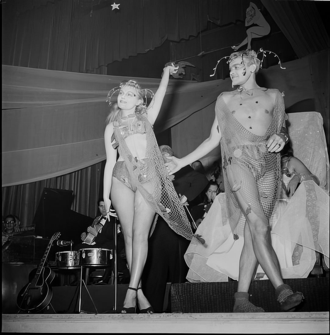 A couple in costume walking across the stage, 1951.