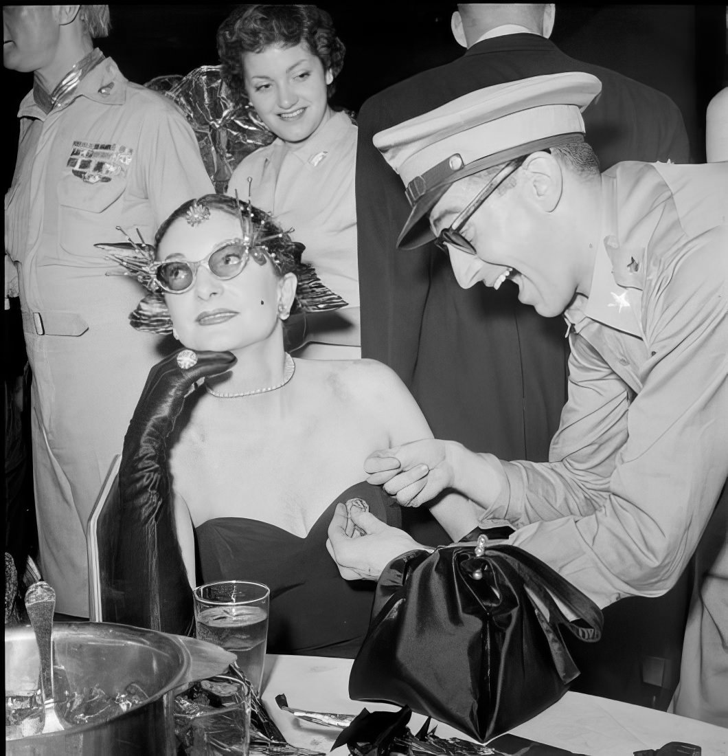 A man interacting with a woman at a table, 1951.